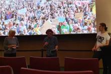 Sara Parkin, Stephen Milder und Yannick Kiefl diskutieren vor dem Leinwand