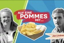 Der Titel "Auf eine Pommes mit..." steht in der Mitte, darunter ist eine Portion Pommes mit Mayo abgebildet, links und rechts sind Halbporträtbilder von Lili und Jan in schwarz/weiß mit Ouline zu sehen. Jan hat eine Holz-Pommesgabel als Bauchbinde. Der Hintergrund ist Grün und Blau mit Lichteffekten. 