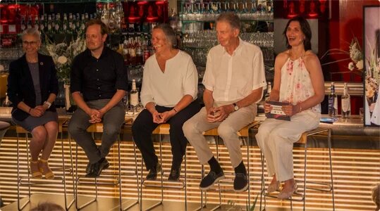Podiumsdiskussion, alle Teilnehmenden sitzen auf Hochstühle