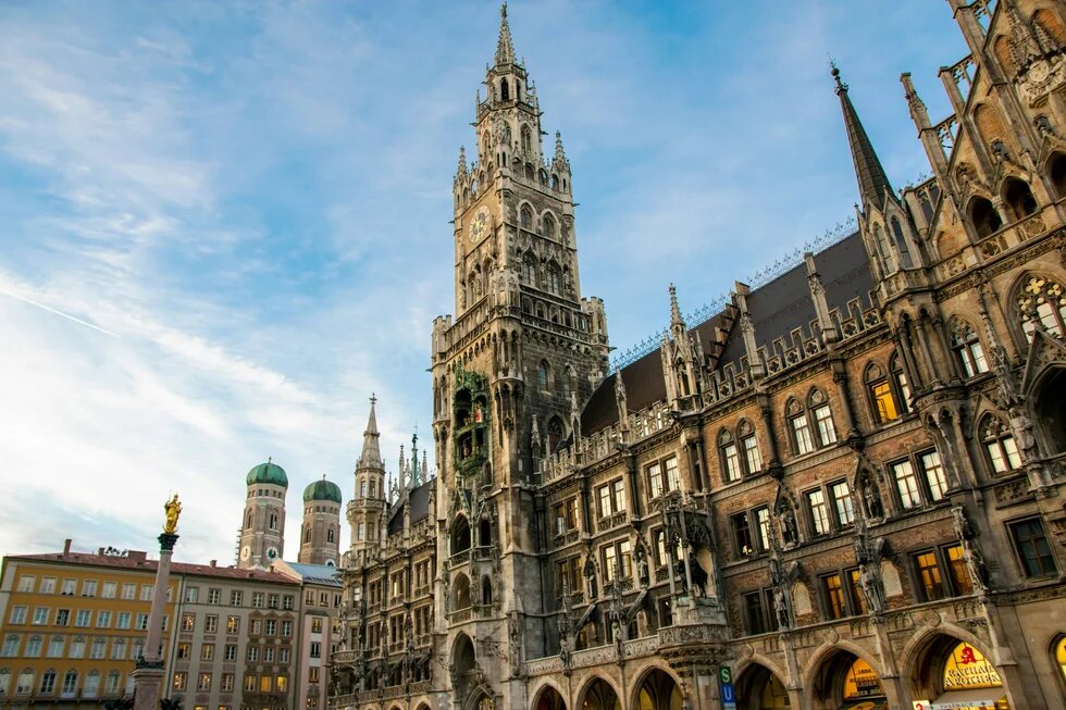 ein großes Gebäude mit einem Uhrturm in der Mitte (Rathaus in München)